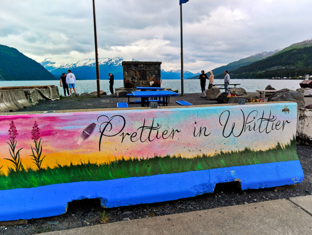Prettier in Whitter Slogan Mural on Concrete Divider with Begich Tower in Whittier Alaska 1