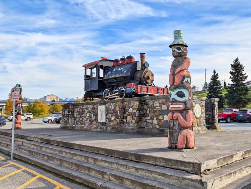 Totem Poles and VIntage Alaska Railroad Engine at Anchorage Train Depot Anchorage Alaska 1