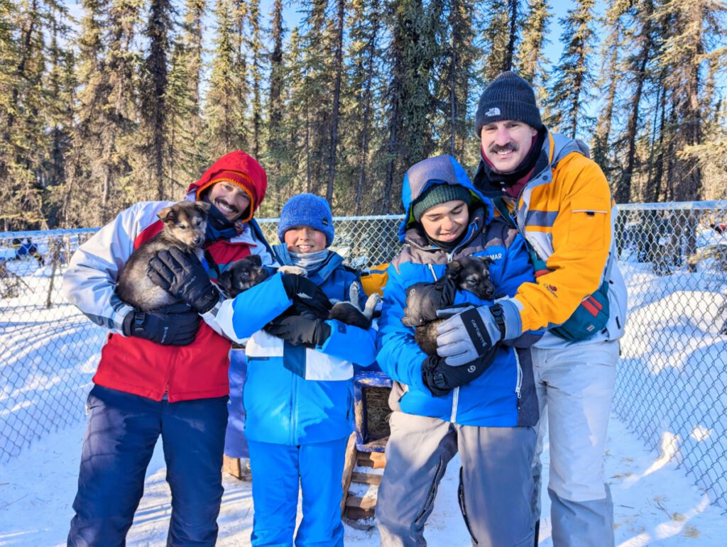 Full Taylor Family holding Sled Dog puppies at Basecamp Adventures Borealis Basecamp Fairbanks Alaska 1