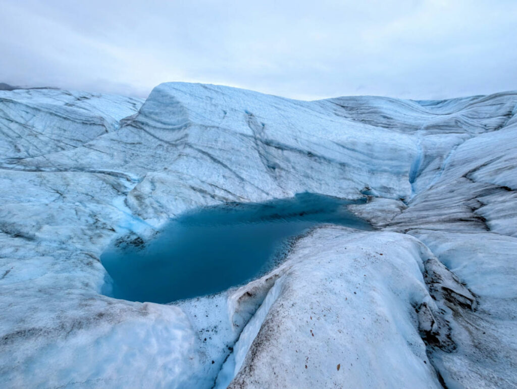 Glacial ice blue pond on Root Glacier with Kennicott Wilderness Guides in Wrangell St Elias National Park McCarthy Alaska