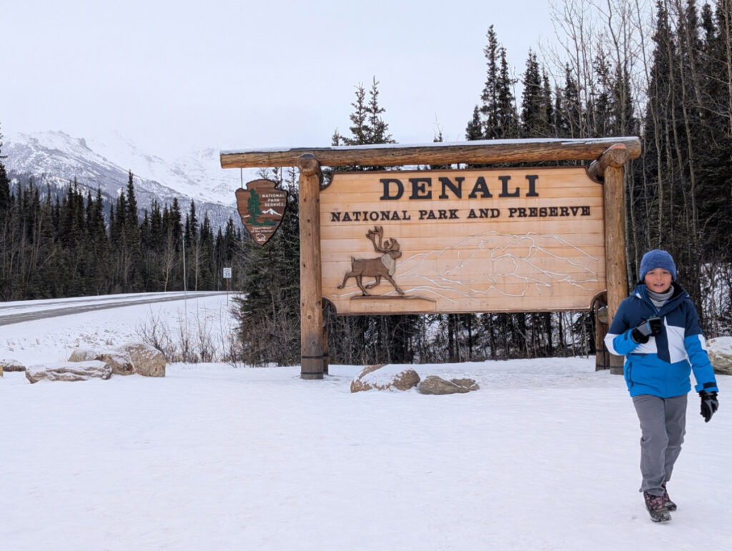 Taylor Family at Entrance Sign to Denali National Park in the snow Alaska