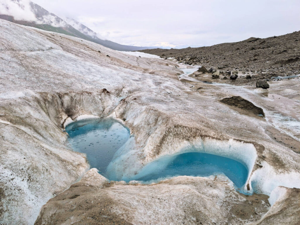 Glacial ice blue pond on Root Glacier with Kennicott Wilderness Guides in Wrangell St Elias National Park McCarthy Alaska